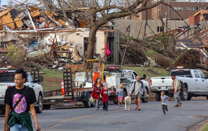 Residents of the Walnut Valley neighborhood walk along Shackleford Road in west Little Rock Friday afternoon, March 31, 2023, after a tornado plowed through the area, damaging hundreds of homes and businesses. (John Sykes/Arkansas Advocate)