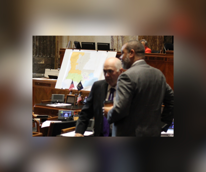 Louisiana Senators talk during a recess of floor debate on a redistricting map (pictured in background) on Feb. 18, 2022. The map fails to include a second Black district. (Wes Muller/Louisiana Illuminator)